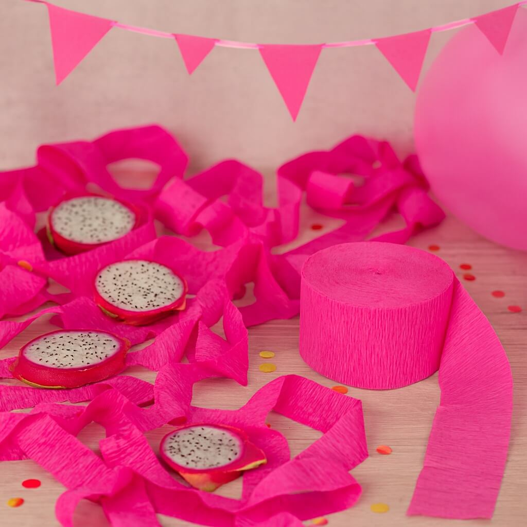 Hot pink crepepapir rulle brugt som festpynt på pyntet festbord med konfetti, vimpler og balloner