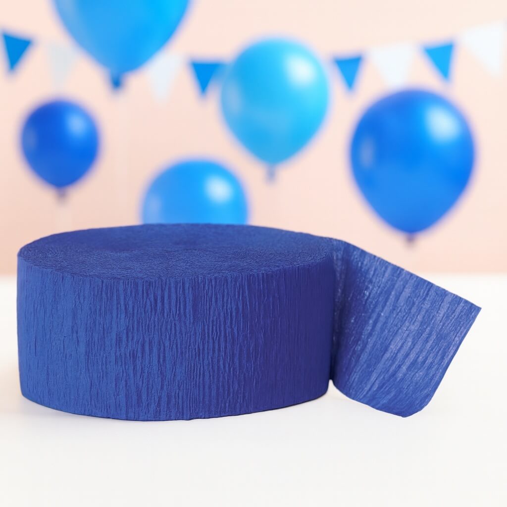 Rulle blåt crepepapir med blå balloner og flagguirlande i baggrunden.