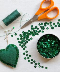 Mørkegrønne runde palietter 6 mm med hul i midten, 500 stk. samlet i et glitrende nærbillede.