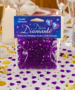 Festligt bord pyntet med lilla hjerte-diamanter, champagneglas og tændte lys omkring en pakke Décor Diamanté pyntesten.