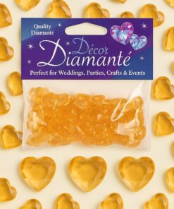 Pose med guldhjerte-pynte diamanter omgivet af løse guldfarvede dekorationshjerter.