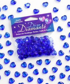 Små safirblå hjerteformede pynte diamanter spredt ud som dekorativ bordpynt på en lys overflade.
