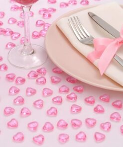 Lyserøde hjerteformede pynte diamanter spredt på en lyserød baggrund.