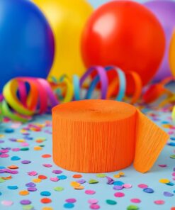 Orange rulle crepepapir omgivet af farverige balloner, konfetti og streamers