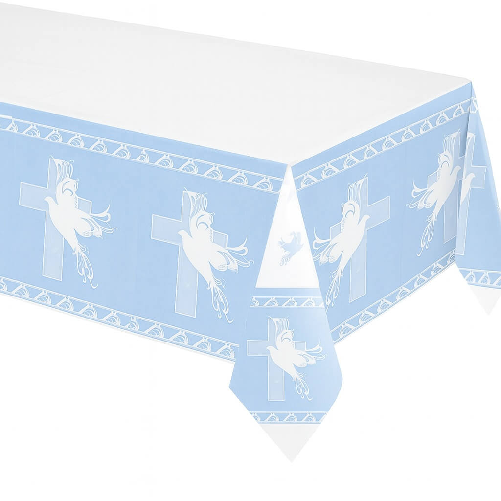 Lyseblå dug med hvide due- og korsmotiver lagt på et bord til barnedåb.