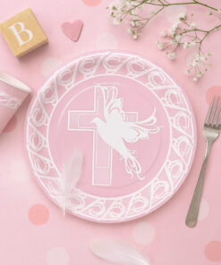 Lyserød barnedåbsborddækning med paptallerken med due og kors, fjer, papkop og pynt i lyserøde nuancer.