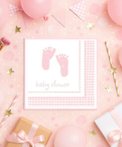 Lyserød babyshower-opdækning med serviet med babyfødder, balloner, gaver og pynt.