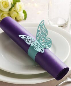 Turkis servietring med sommerfugl på lilla serviet – elegant borddækning til festlige begivenheder.