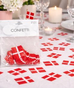 Pose med Dannebrog confetti på festligt dækket bord med flag, lys og blomster