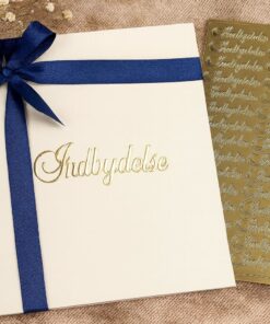 Indbydelse med blåt satinbånd og guldtekst ved siden af ark med guldstickers med ordet “Indbydelse”.