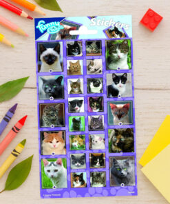 Stickersark med mange forskellige katte placeret på lys træbaggrund omgivet af farveblyanter, blade, LEGO-klods og gule papirer