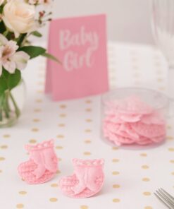 Små lyserøde hæklede sokker som bordpynt til barnedåb og babyshower