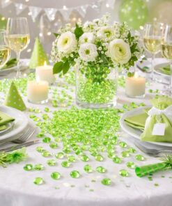 Pyntet festbord med limegrønne pynte diamanter, hvide blomster og lys som bordpynt til fest og bryllup.