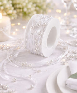 Hvidt satinbånd med perler på spole brugt som dekorativ bordpynt.