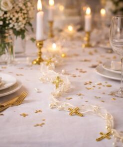 Elegant bordpynt i hvid og guld med perlebånd og små guldkors på opdækket festbord med stearinlys og glas