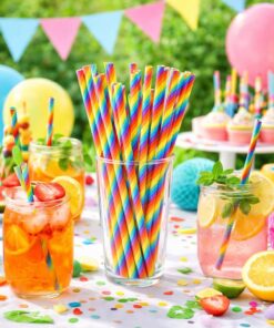 Farverige papsugerør i regnbuefarver på pyntet festbord med drinks, cupcakes og balloner til børnefødselsdag