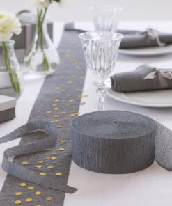 Gråt crepepapir på rulle anvendt som bordløber på pyntet festbord med glas, servietter og konfetti.