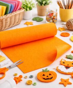 Kreativt hobbybord med orange hobbyfilt, filtfigurer, sakse, knapper og DIY-materialer