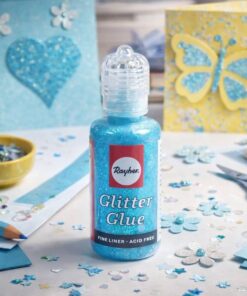 Lyseblå glitterlim i kreativ hobbyopsætning med kort, pynt og diy dekoration