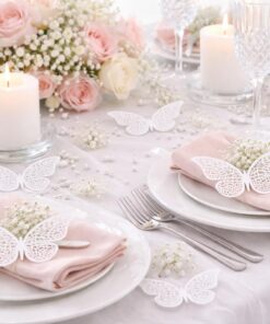 Pyntet festbord med hvide dekorations sommerfugle som bordpynt, lys og blomsterdekoration