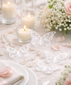 Stemningsbillede af hvide dekorations sommerfugle som bordpynt på pyntet festbord med lys og blomster