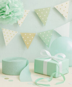 Mint grønt crepepapir på rulle brugt til festdekoration i lyse pastelfarver med gave, ballon og pynt