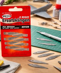 Pakke med skalpelblade nr. 65129 og løse knivblade på hobbybord med skæremåtte og præcisionsskalpel til modelbyg