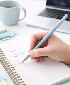 Faber-Castell Grip 2001 blyant i lyseblå brugt til skrivning i notesbog på skrivebord