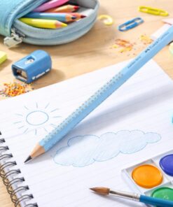Faber-Castell Jumbo Grip blyant i lyseblå ligger på notesbog med tegning omgivet af skoletilbehør