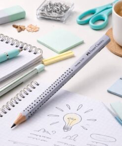 Faber-Castell Jumbo Grip blyant i sølv på skrivebord med notesbog og kontorartikler