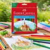 Faber-Castell Slot farveblyanter i brug på træbord med farvelagt tegning, farveblyanter og original æske i baggrunden