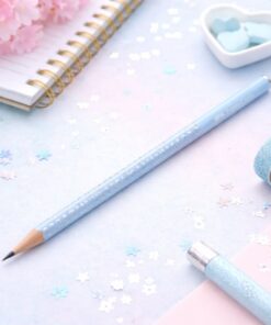 Faber-Castell Sparkle blyant i lyseblå med glitter på kreativt skrivebord med notesbog og pastelfarvet tilbehør