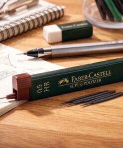 Faber-Castell Super-Polymer 0.5 HB stifter i grøn dispenser med løse stifter på skrivebord ved notesbog og stiftblyant