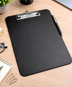 Sort A4 clipboard med metalklemme og penholder på skrivebord med kontorartikler og kaffekop