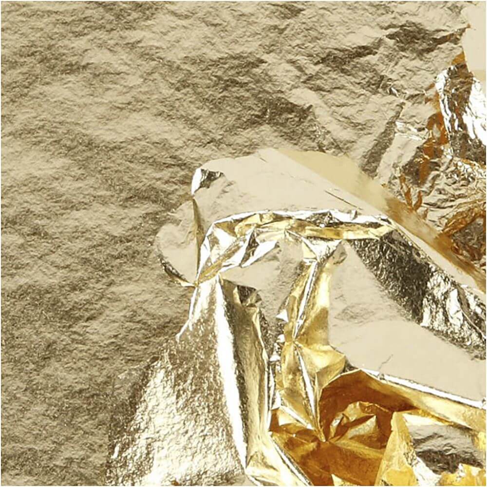 Bladmetal guld, tynde dekorationsark i metallisk guld, der påføres en hvid genstand med en pensel i et kreativt DIY-projekt.