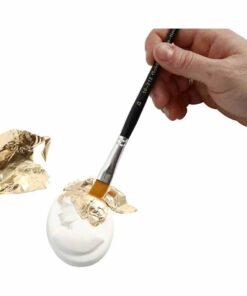 Bladmetal guld, tynde dekorationsark i metallisk guld, der påføres en hvid genstand med en pensel i et kreativt DIY-projekt.