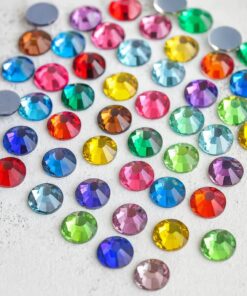 Farverige facetslebne rhinsten i 6 mm mix, spredt i en dekorativ samling til kreative projekter og DIY.
