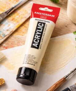 Amsterdam Standard Naples Yellow Light akrylmaling 120 ml tube på malebord med pensler og gul maling på lærred