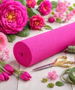 Florist crepepapir i intens fuchsia farve med håndlavede papirblomster og blomsterbindingsværktøj på arbejdsbord