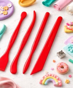 Røde FIMO modelleringsknive i plast til lerarbejde omgivet af farverige polymer ler figurer og hobbyprojekter på lys baggrund