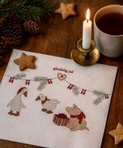 Juleservietter med teksten Glædelig Jul i røde og hvide julefarver, placeret på et festligt dækket julebord.