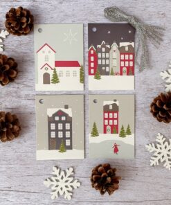 Fire jule-gavemærker med vinterby-motiver i røde, grå og hvide farver, omgivet af pyntegrankogler og træ-snefnug på en lys træbaggrund