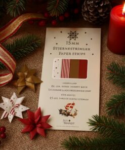 Pakke med stjernestrimler i fire julemotiver omgivet af flettede papirjulestjerner, gran og et tændt rødt lys.